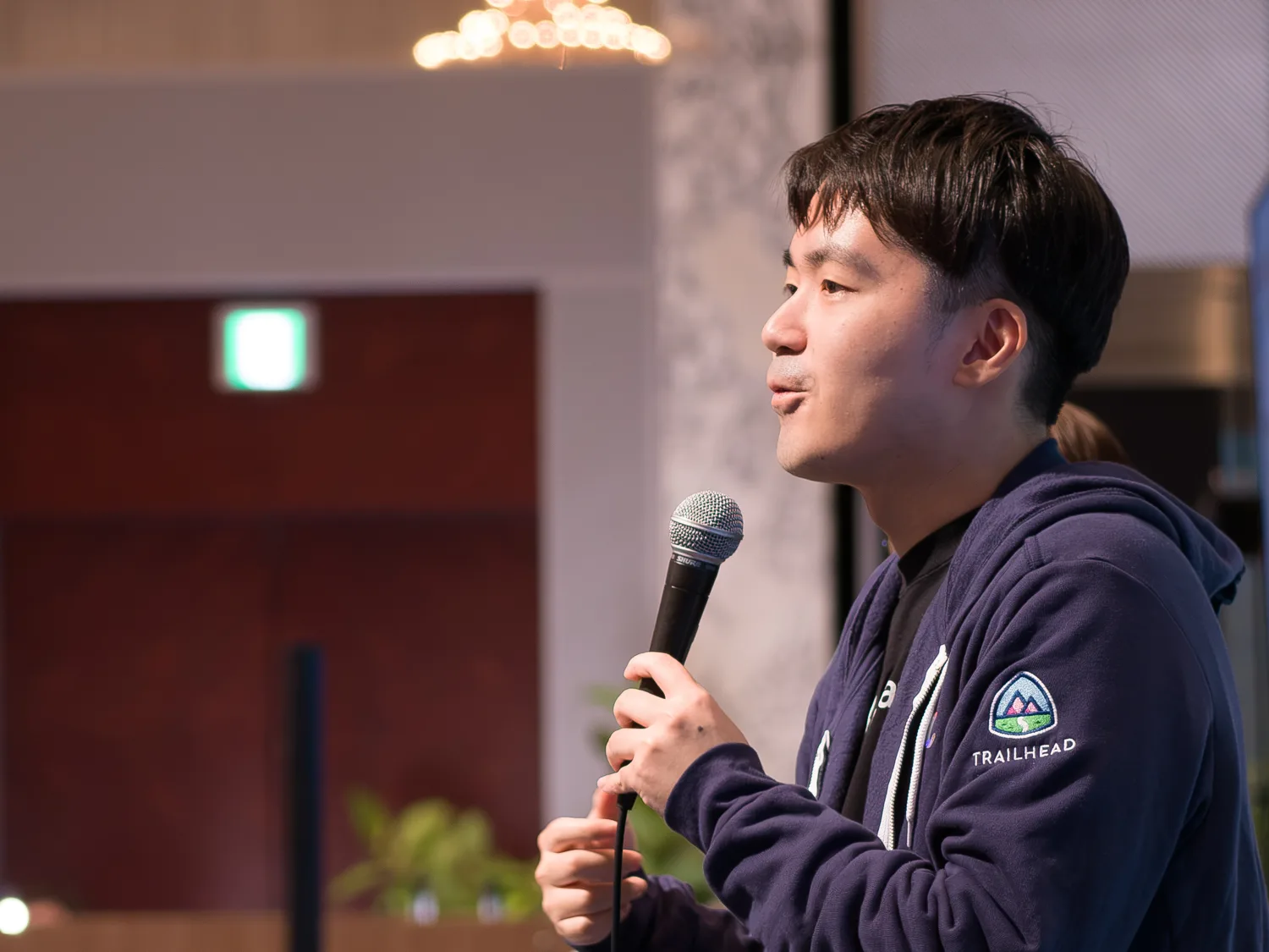 イベント会場でマイクを持って語りかけるメンバー