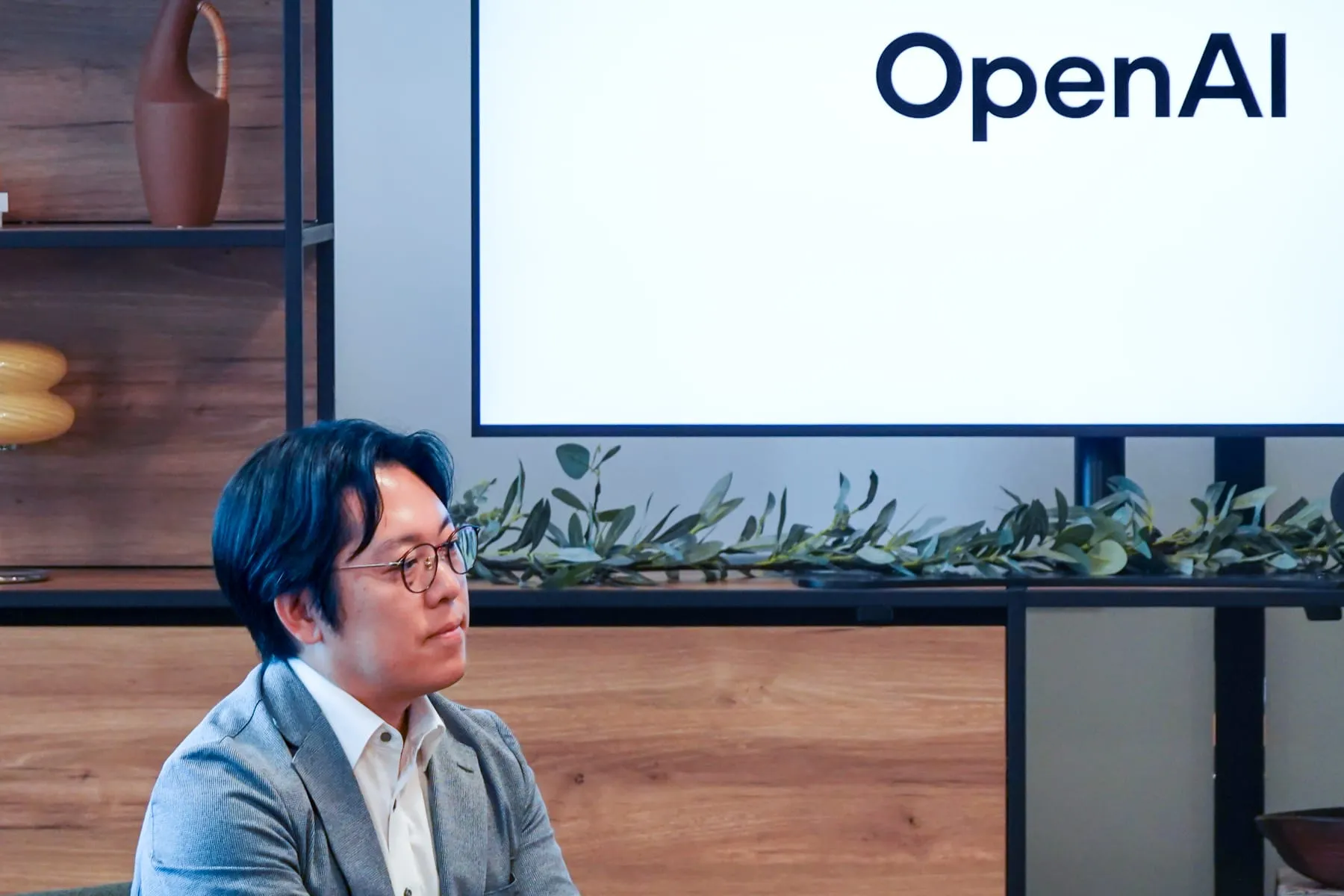 座談会に登壇したリバネスナレッジ代表取締役社長 吉田丈治。背景には OpenAI のロゴを表示したディスプレイが見える